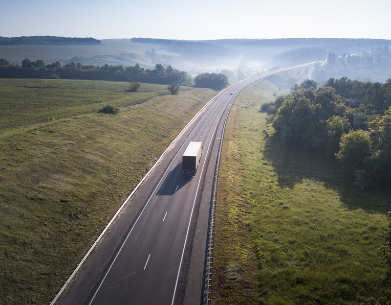 Aerial Top View of White Truck with Cargo Semi Trailer Moving on Road in Direction.
