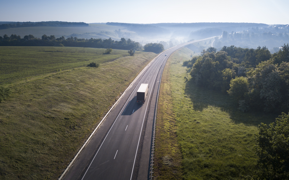 Aerial Top View of White Truck with Cargo Semi Trailer Moving on Road in Direction.